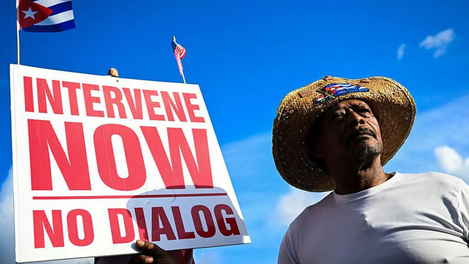 Getty Images Man holding an "intervene now" sign in Miami, Florida. 